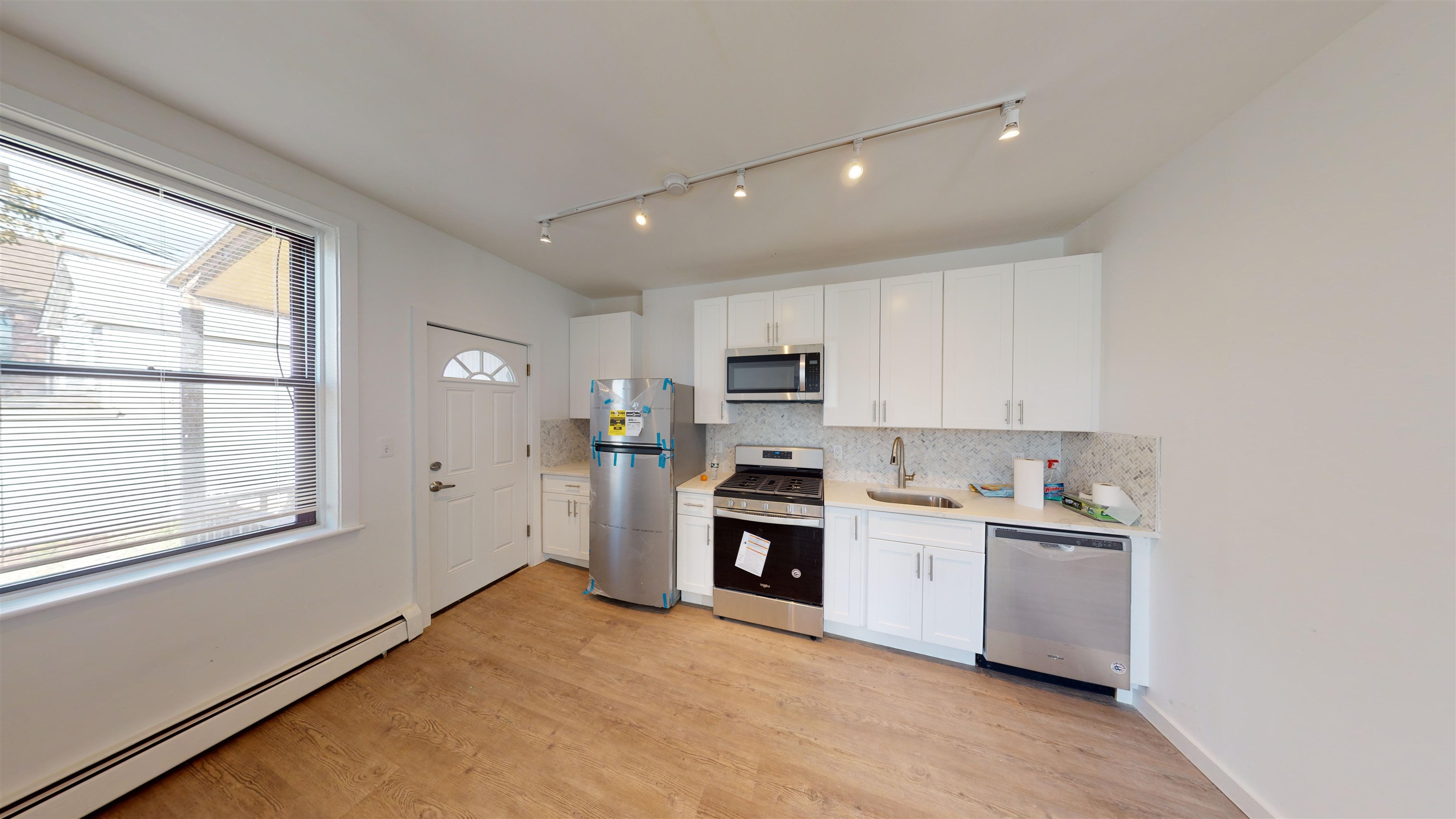 a kitchen with cabinets stainless steel appliances and a window