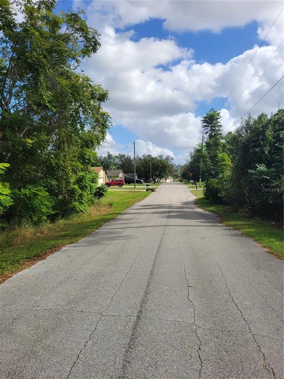 a view of a road with a yard and a house