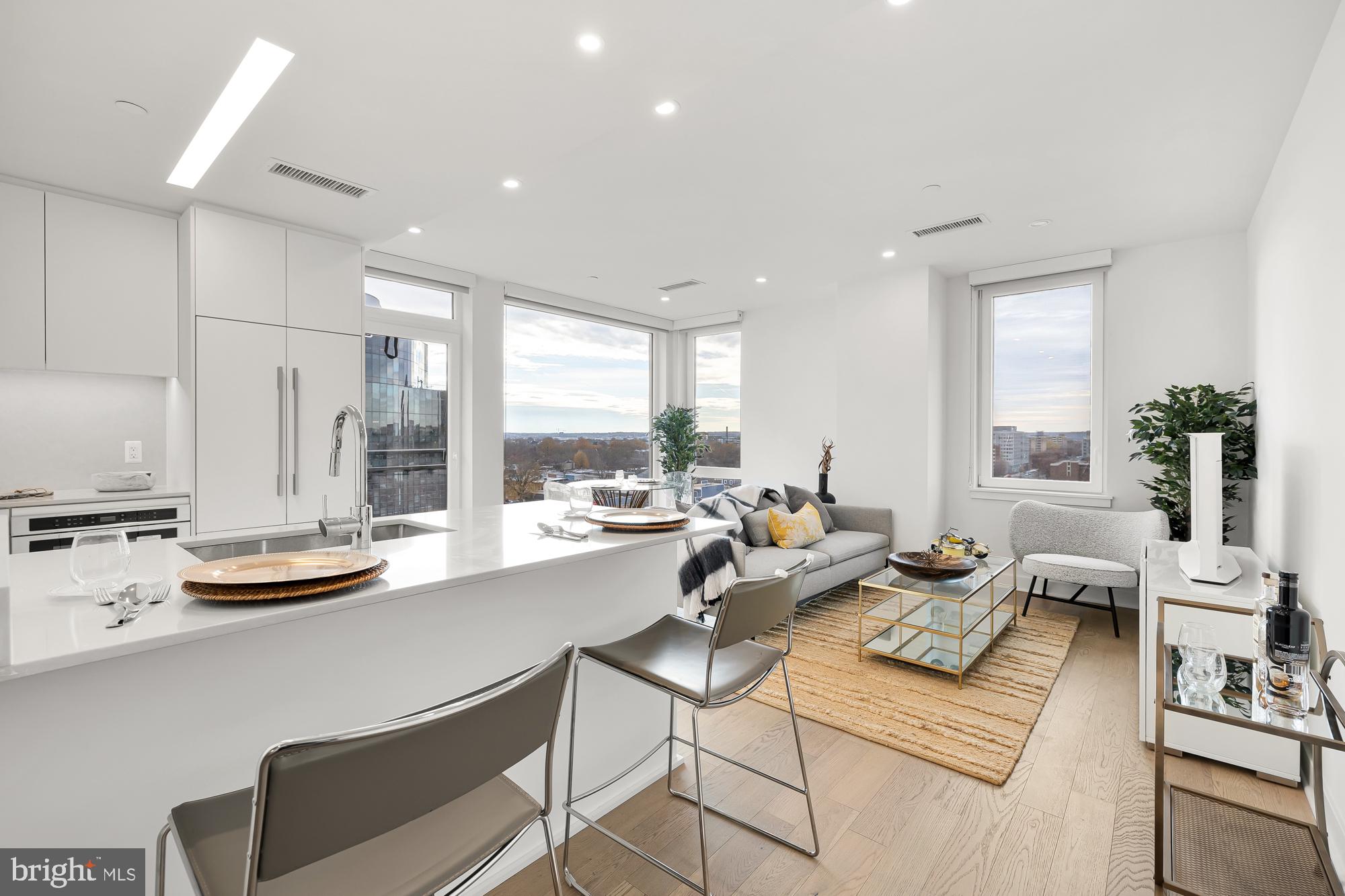 a living room with furniture kitchen and a large window