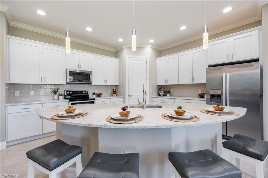 a kitchen with a sink a stove and chairs with wooden floor