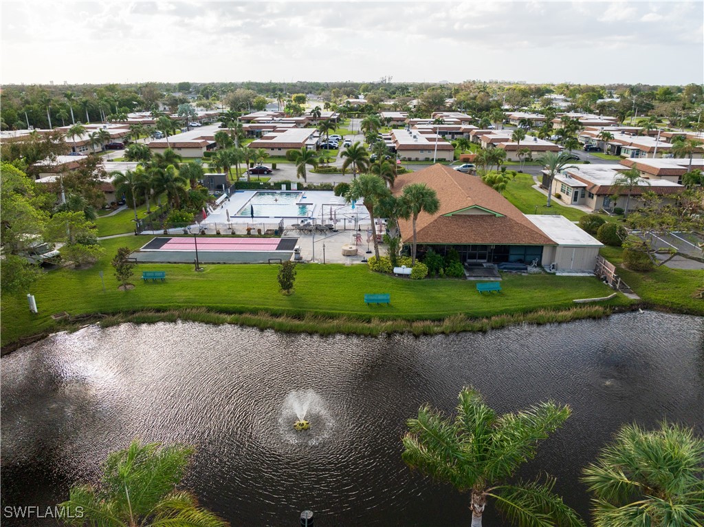 an aerial view of a house with a yard and lake view in back