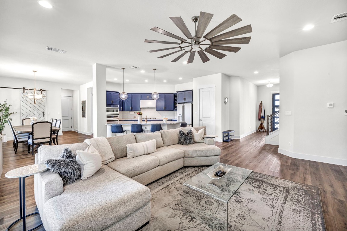 a living room with furniture kitchen view and a large window