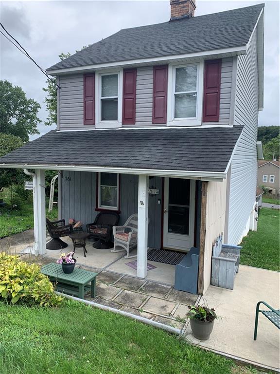 a front view of a house with sitting area and garden