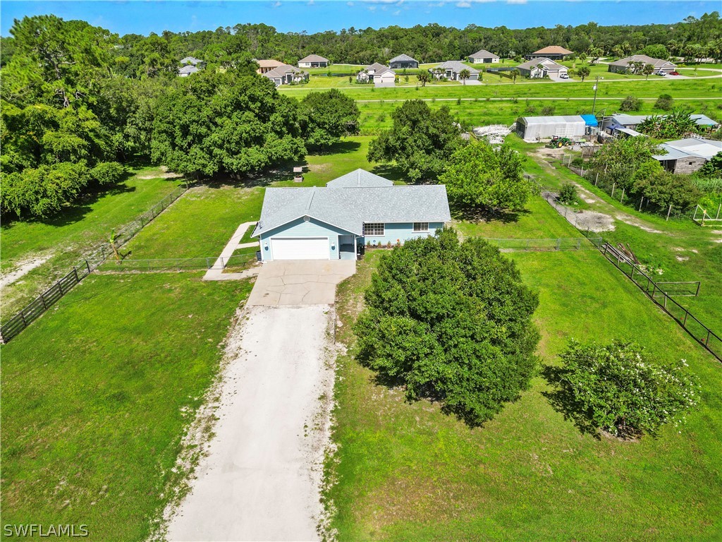 an aerial view of residential houses with outdoor space and trees