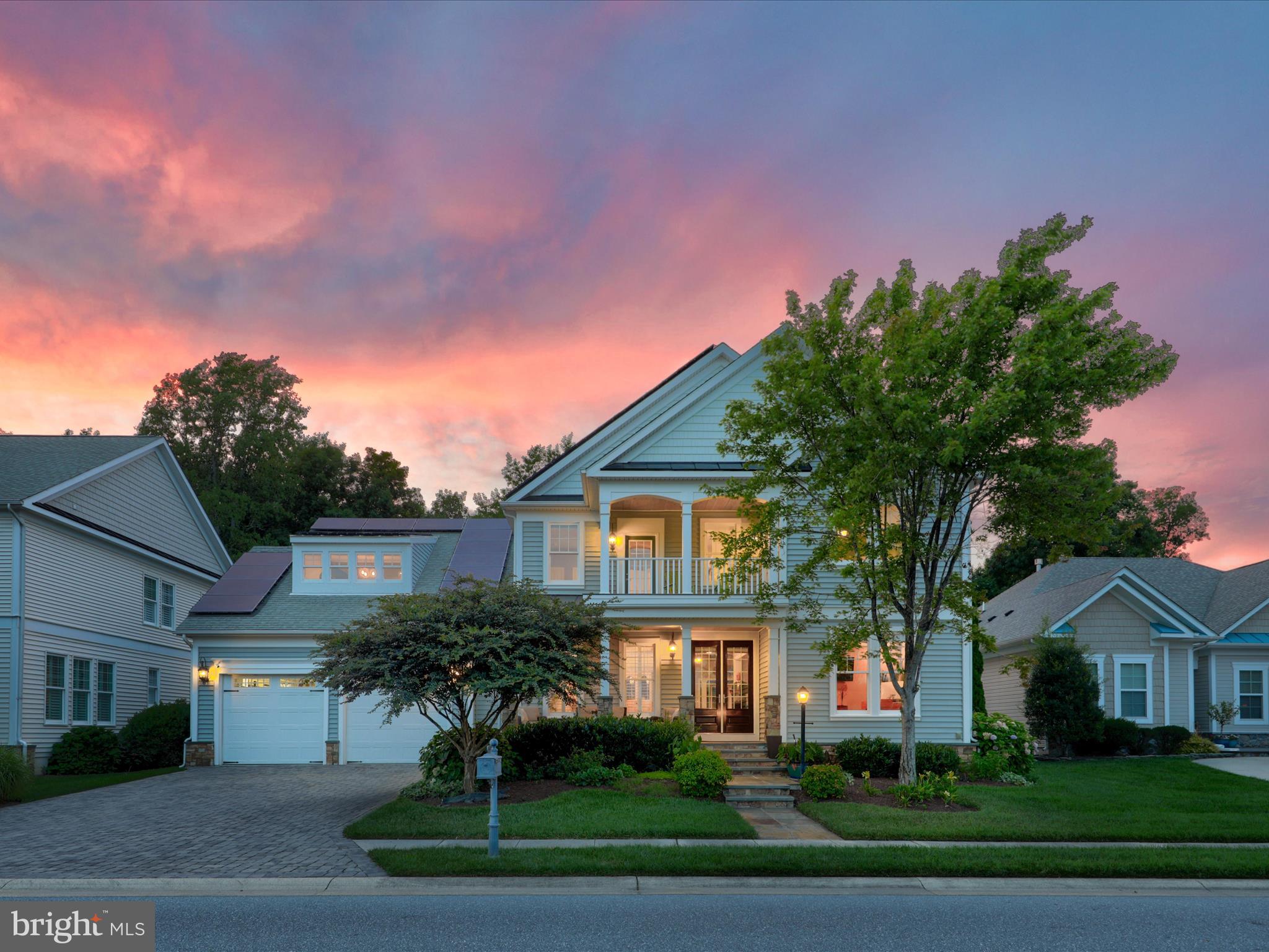 a front view of a house with a yard and trees