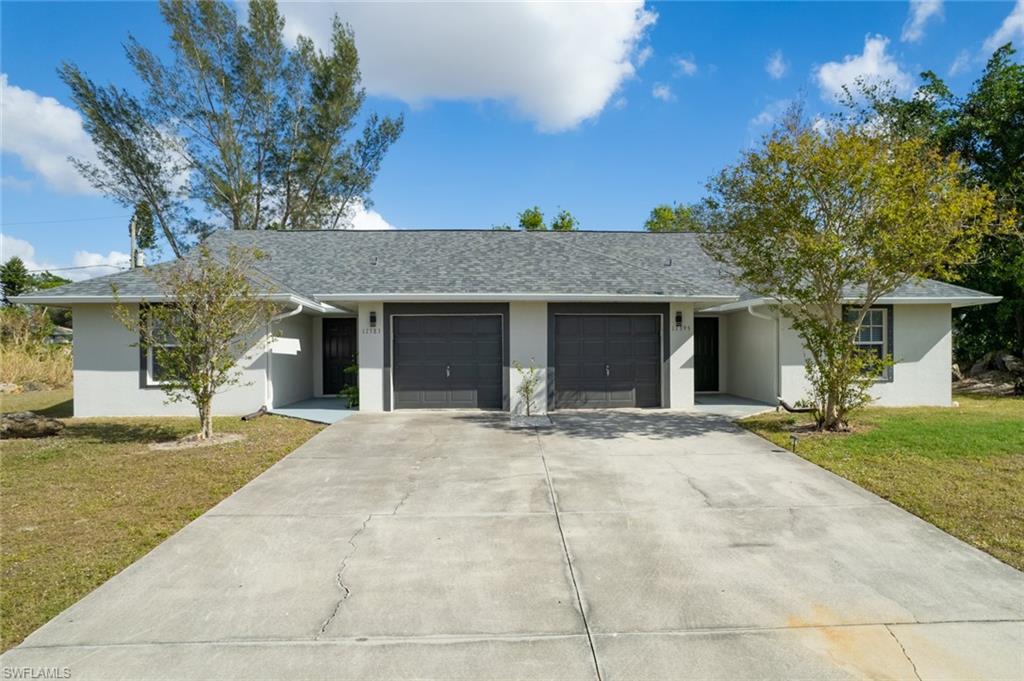 Ranch-style house featuring a front yard and a garage