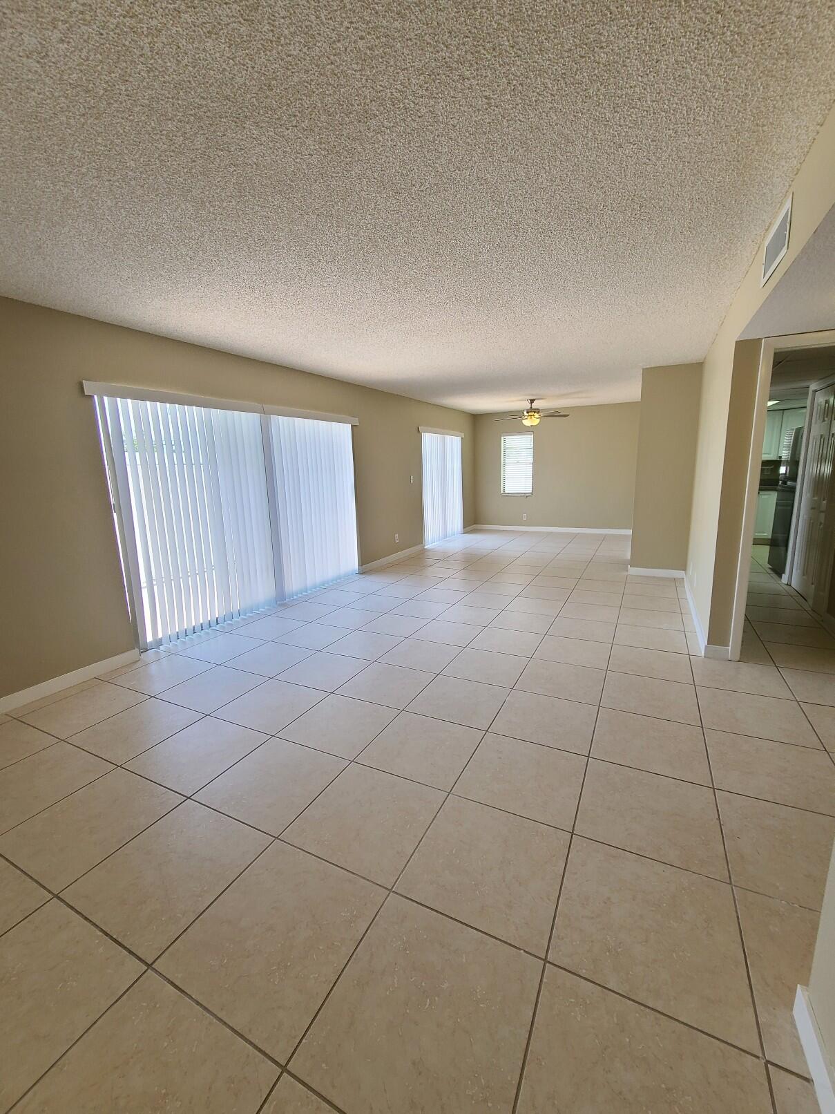 a view of an empty room with stairs and a window