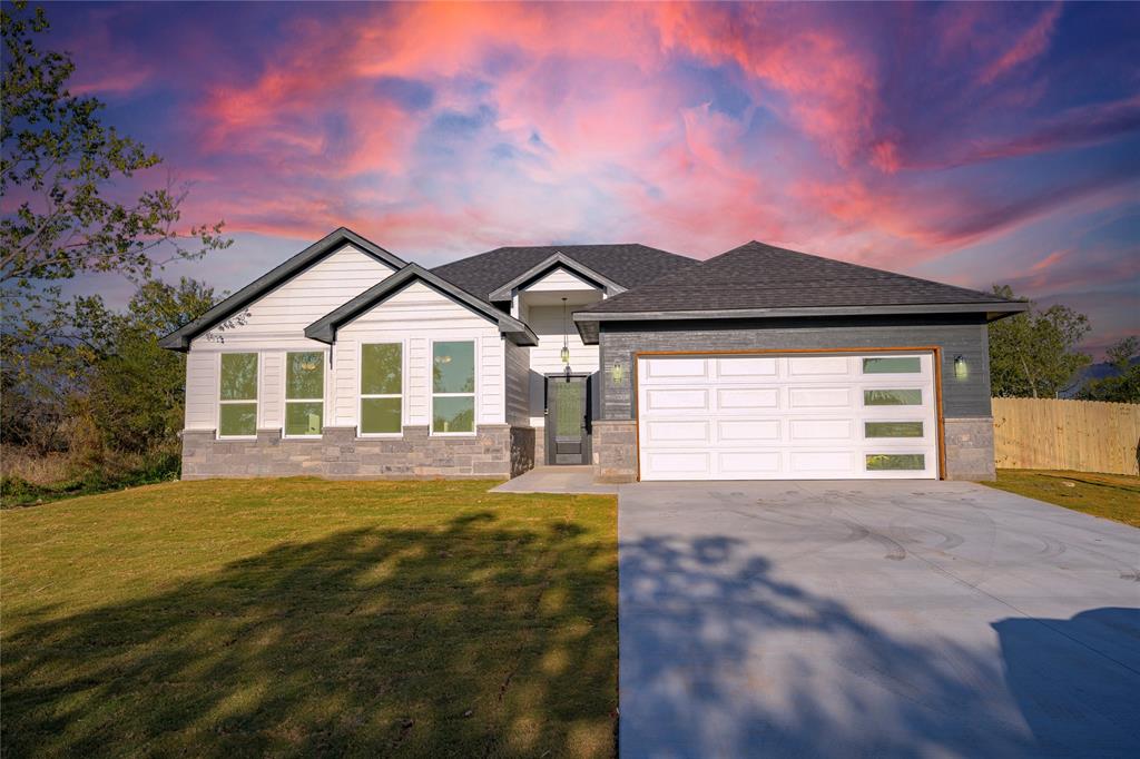 a front view of a house with a garden and yard