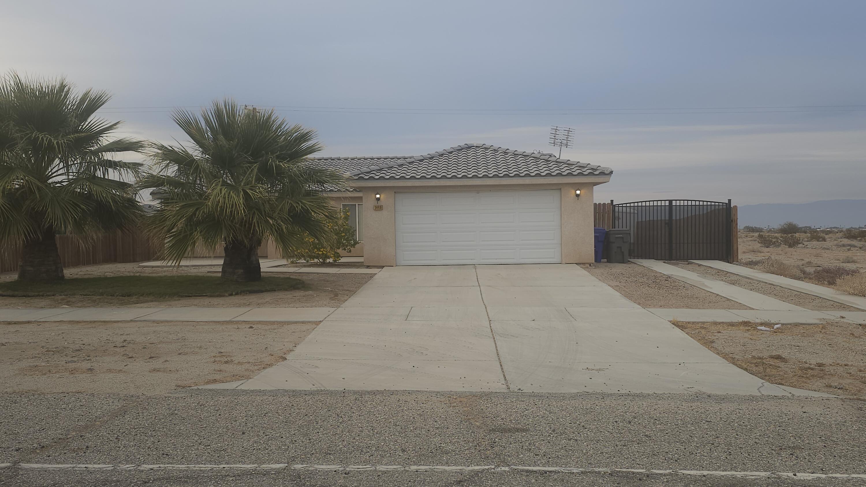 a view of a house with a yard and palm trees