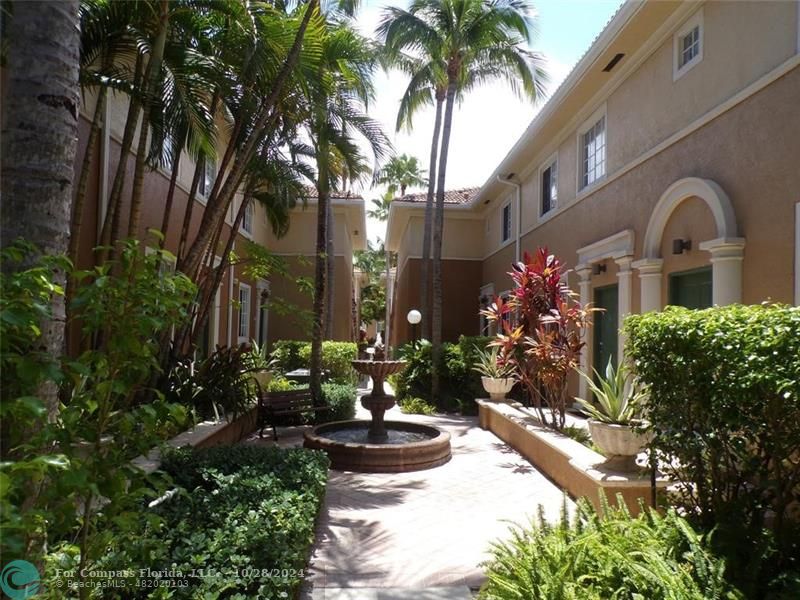 a front view of a house with a yard and potted plants