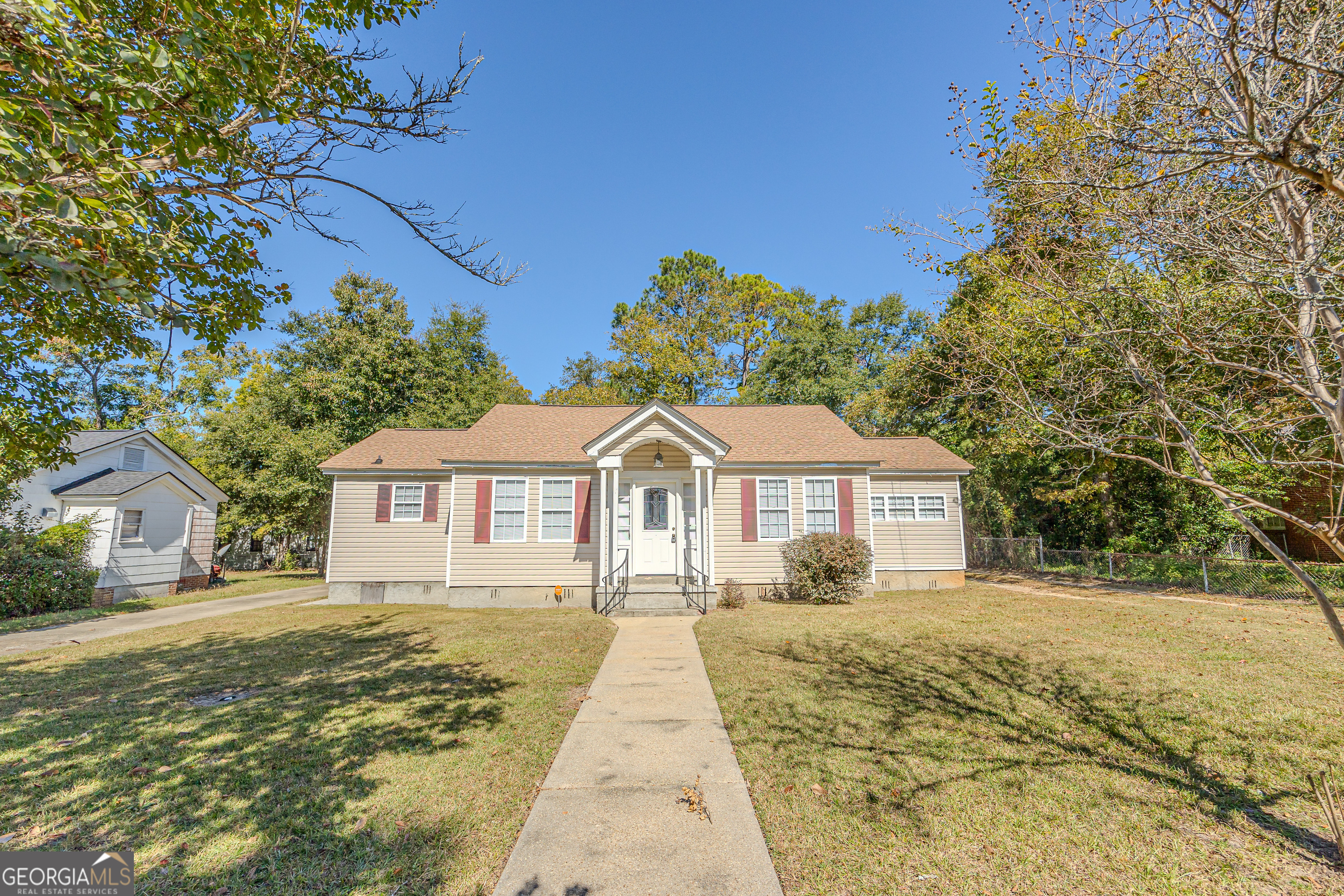 a front view of a house with a yard and trees