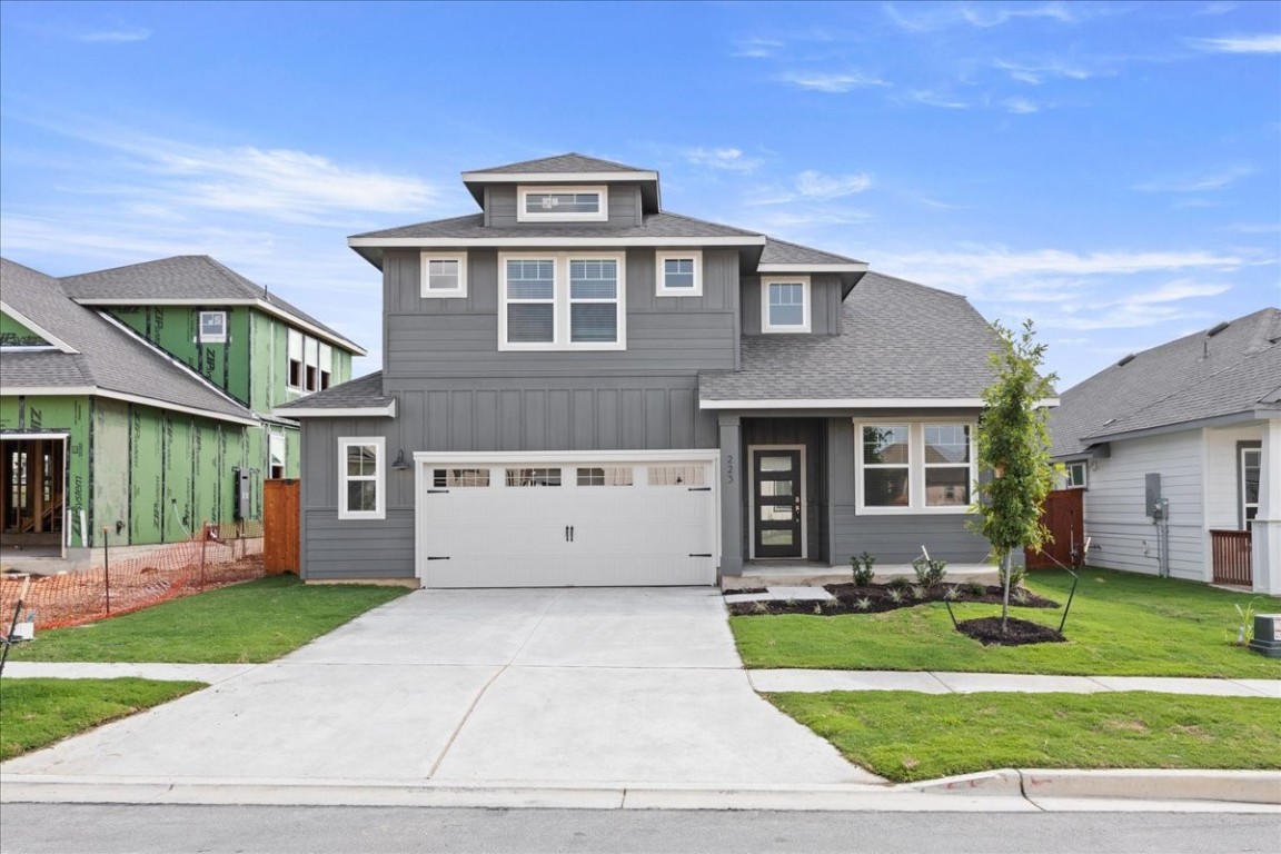 a front view of a house with a yard and garage