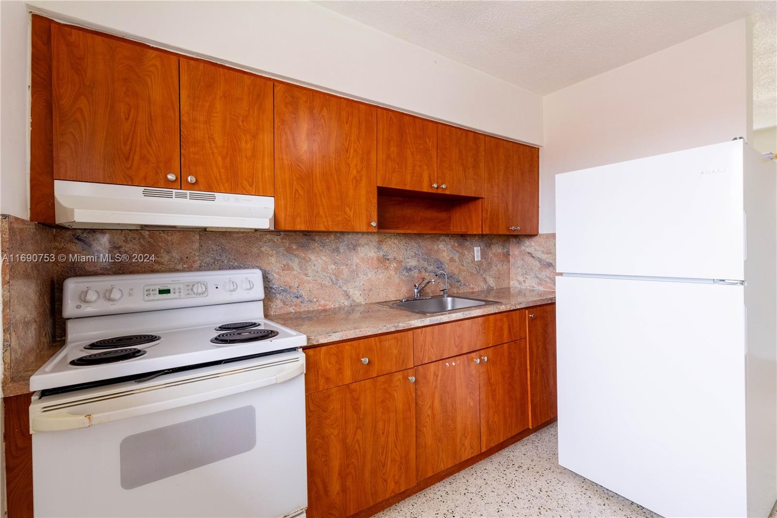 a kitchen with stainless steel appliances wooden cabinets and a stove top oven