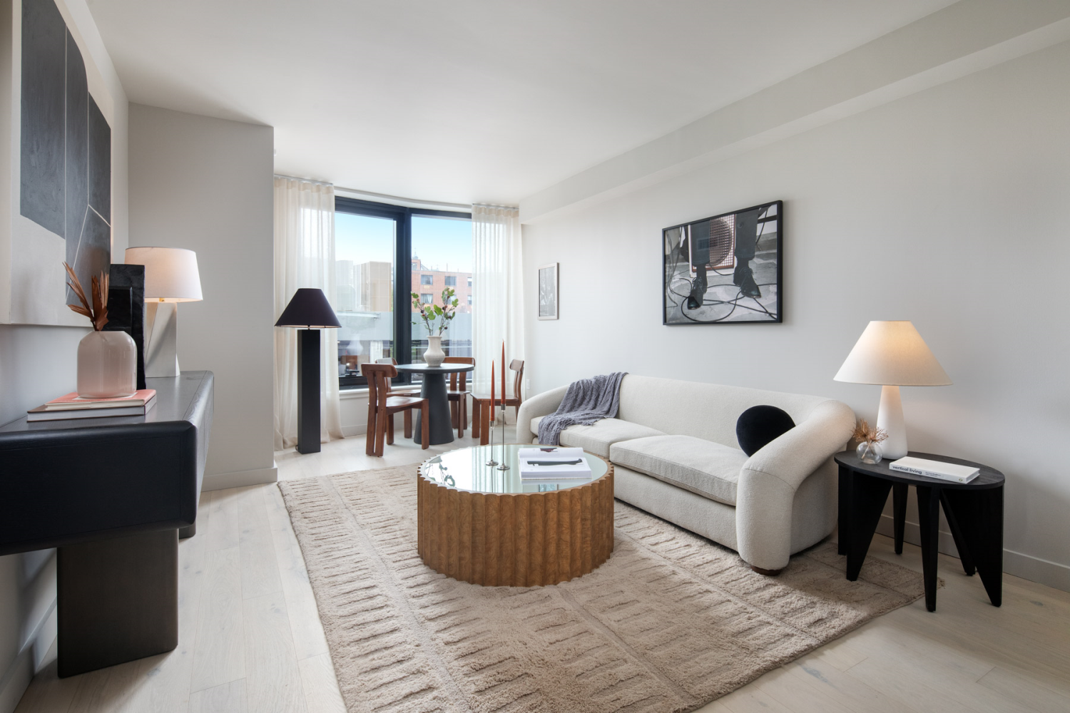 a living room with furniture and a large mirror next to a window