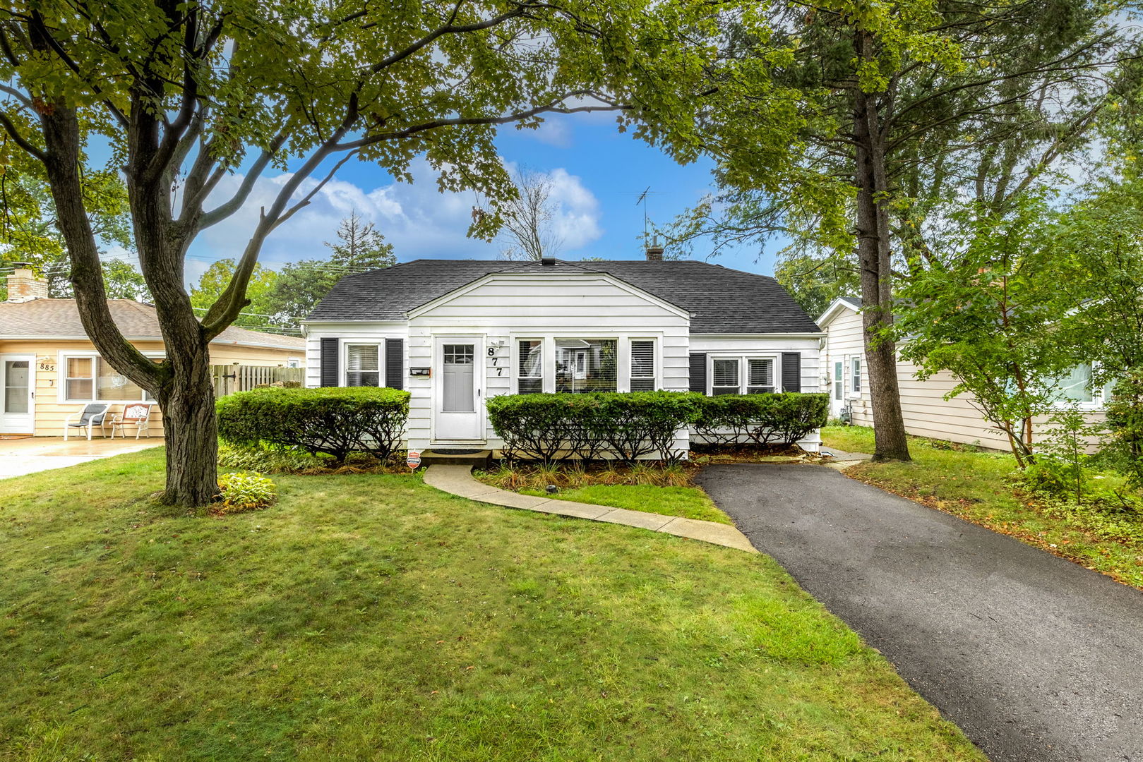 a front view of a house with yard patio and green space