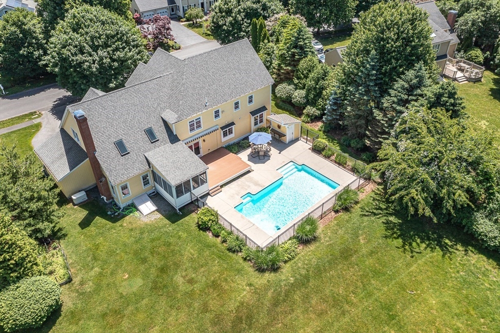 an aerial view of a house with a yard and trees