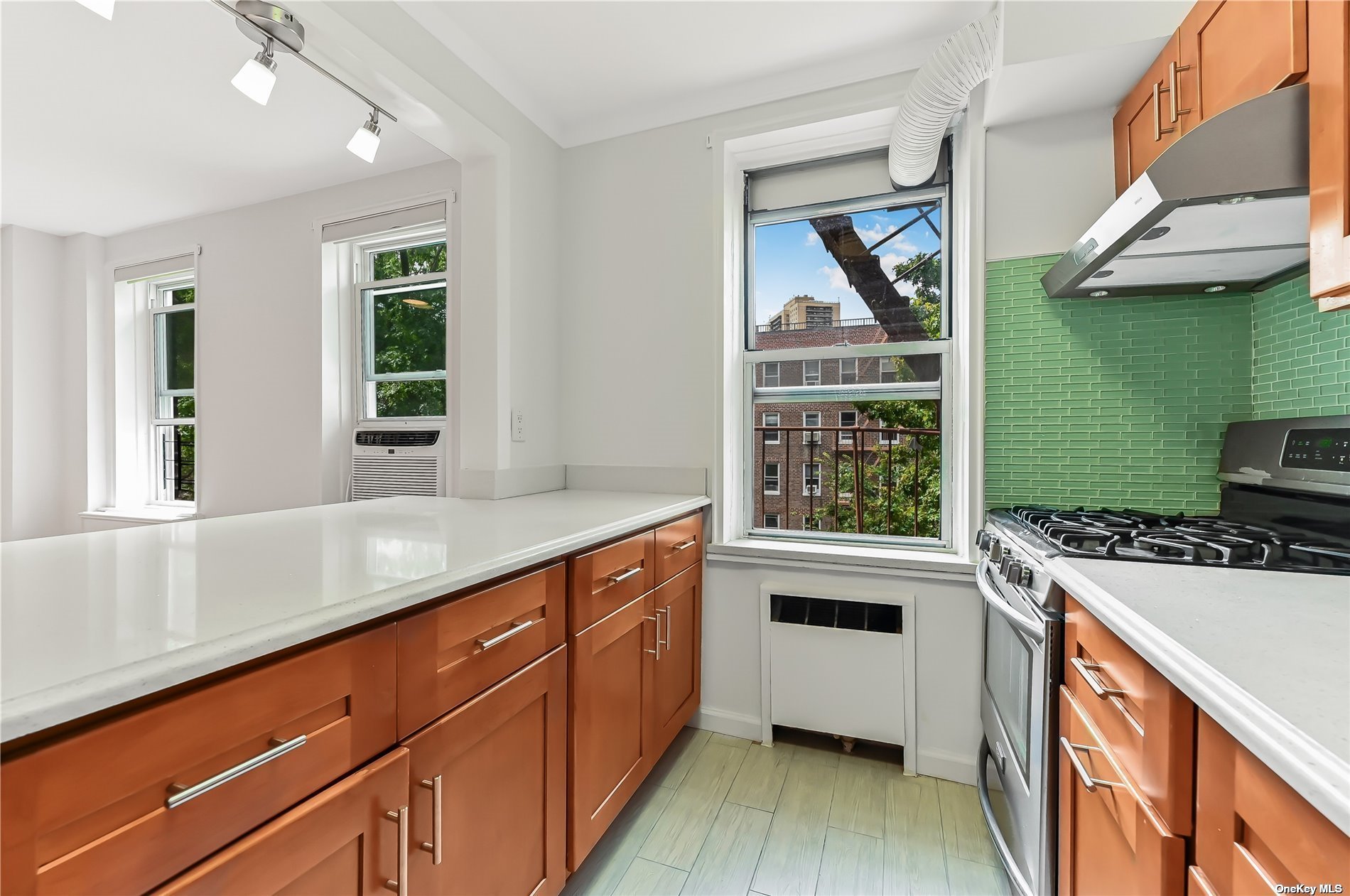 a kitchen with stainless steel appliances granite countertop a sink and a stove with wooden floor