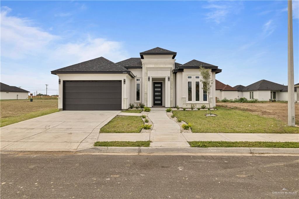 Prairie-style house featuring a front yard and a garage