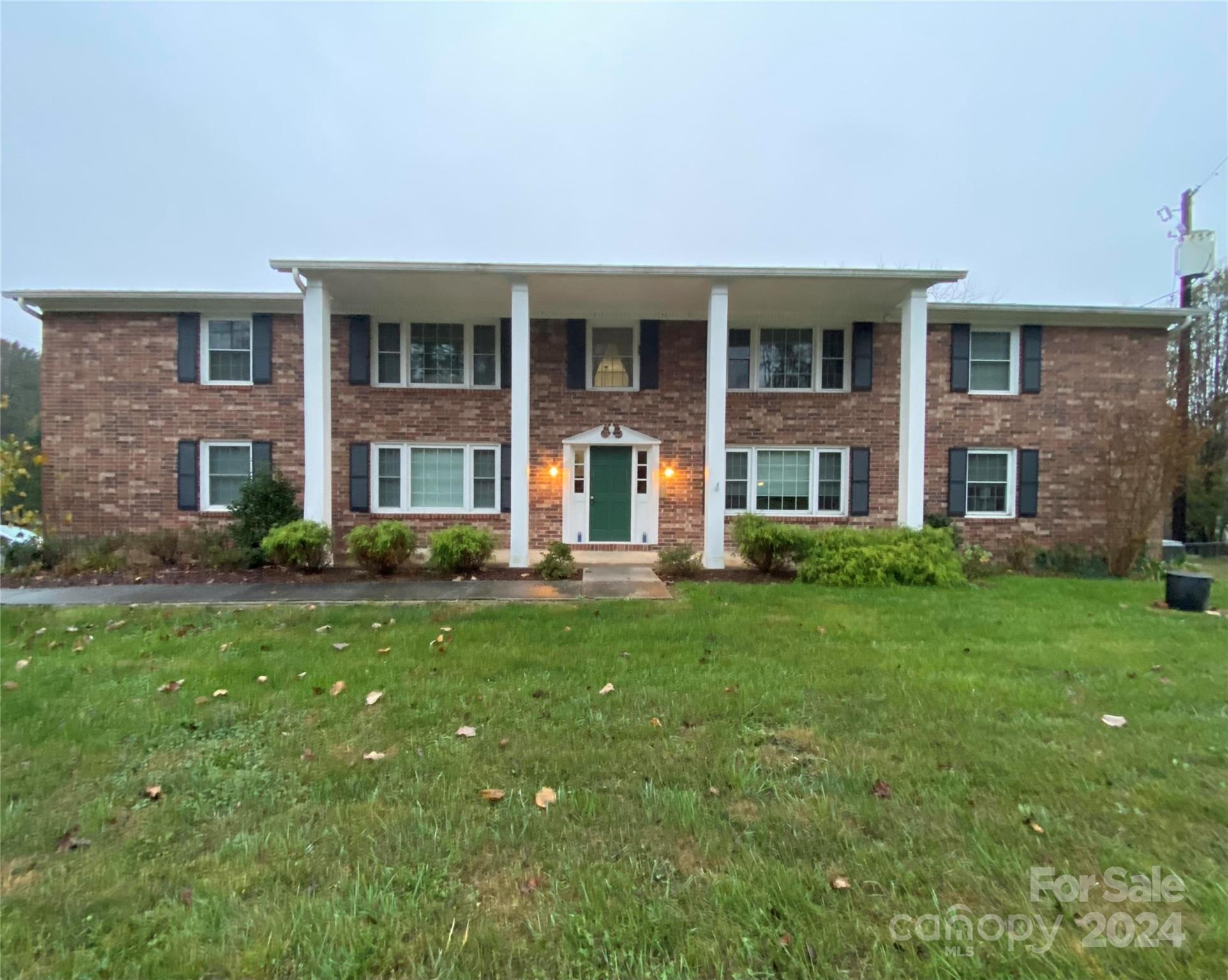 front view of a brick house with a yard