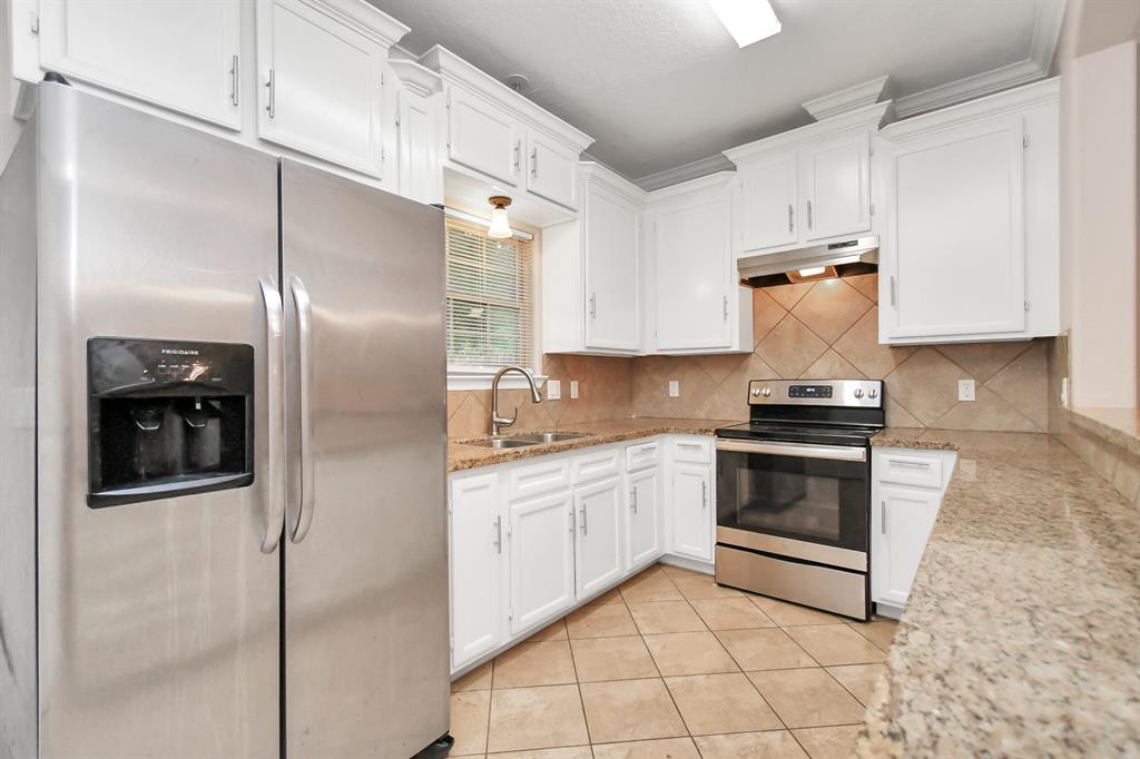 a kitchen with stainless steel appliances granite countertop a stove a refrigerator and a sink