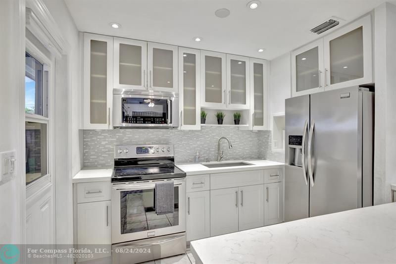 a kitchen with stainless steel appliances granite countertop a stove and a refrigerator