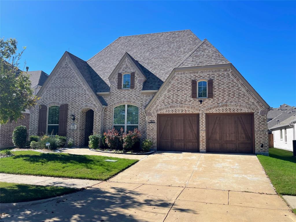 a front view of brick house with a yard