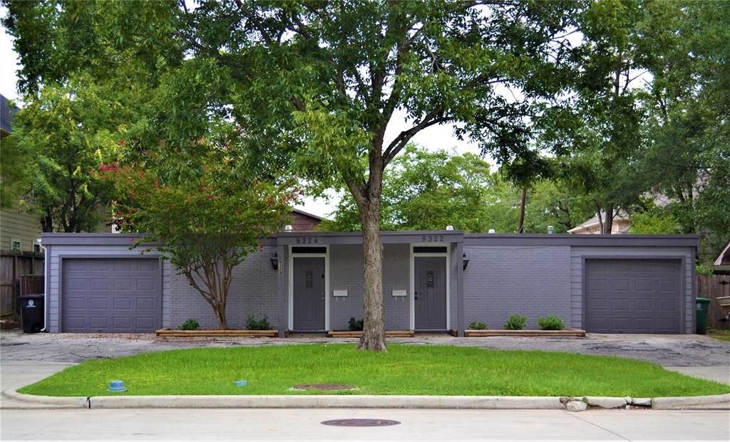 a front view of a house with a yard and a garage