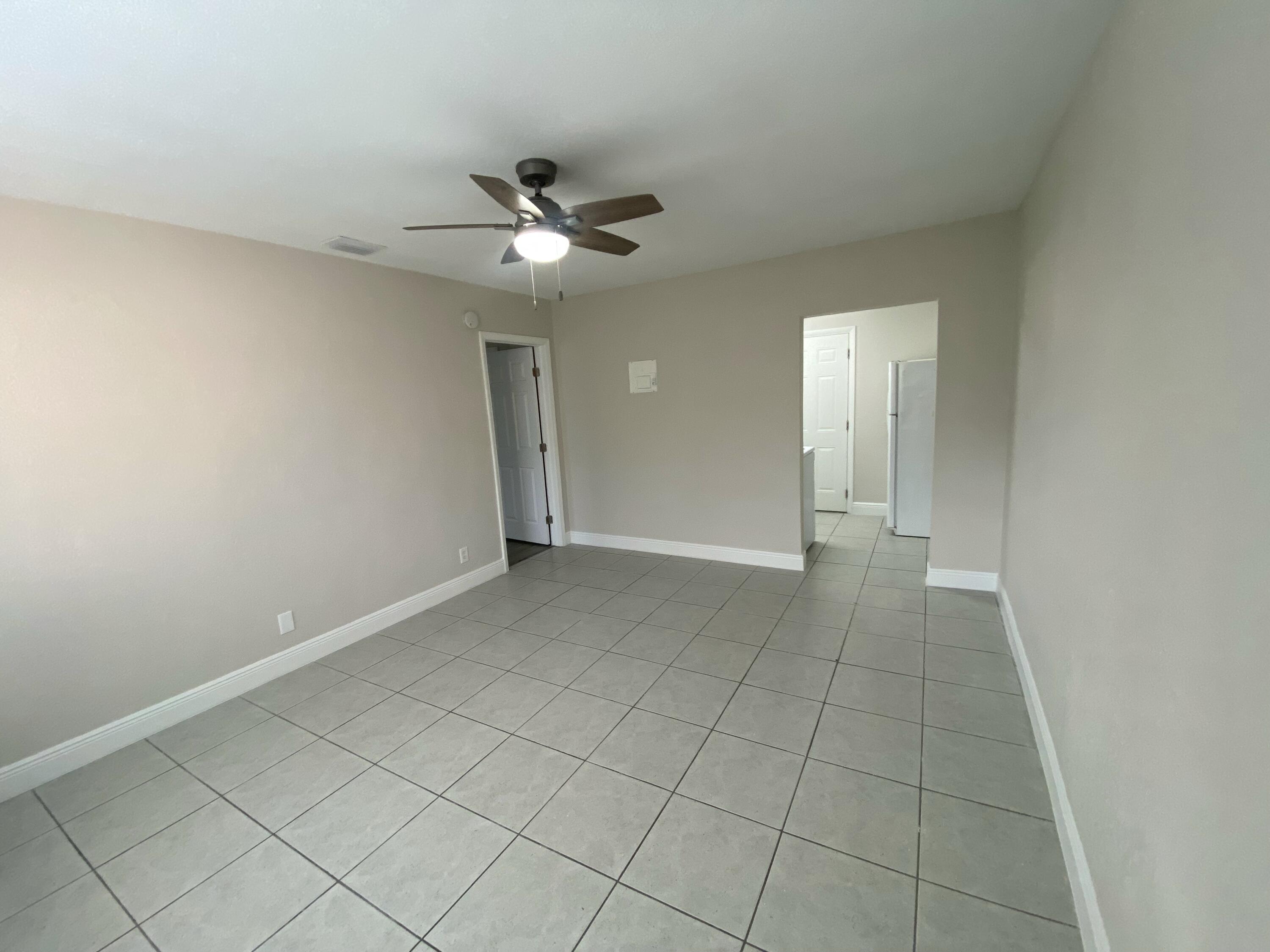 an empty room with closet and a chandelier fan