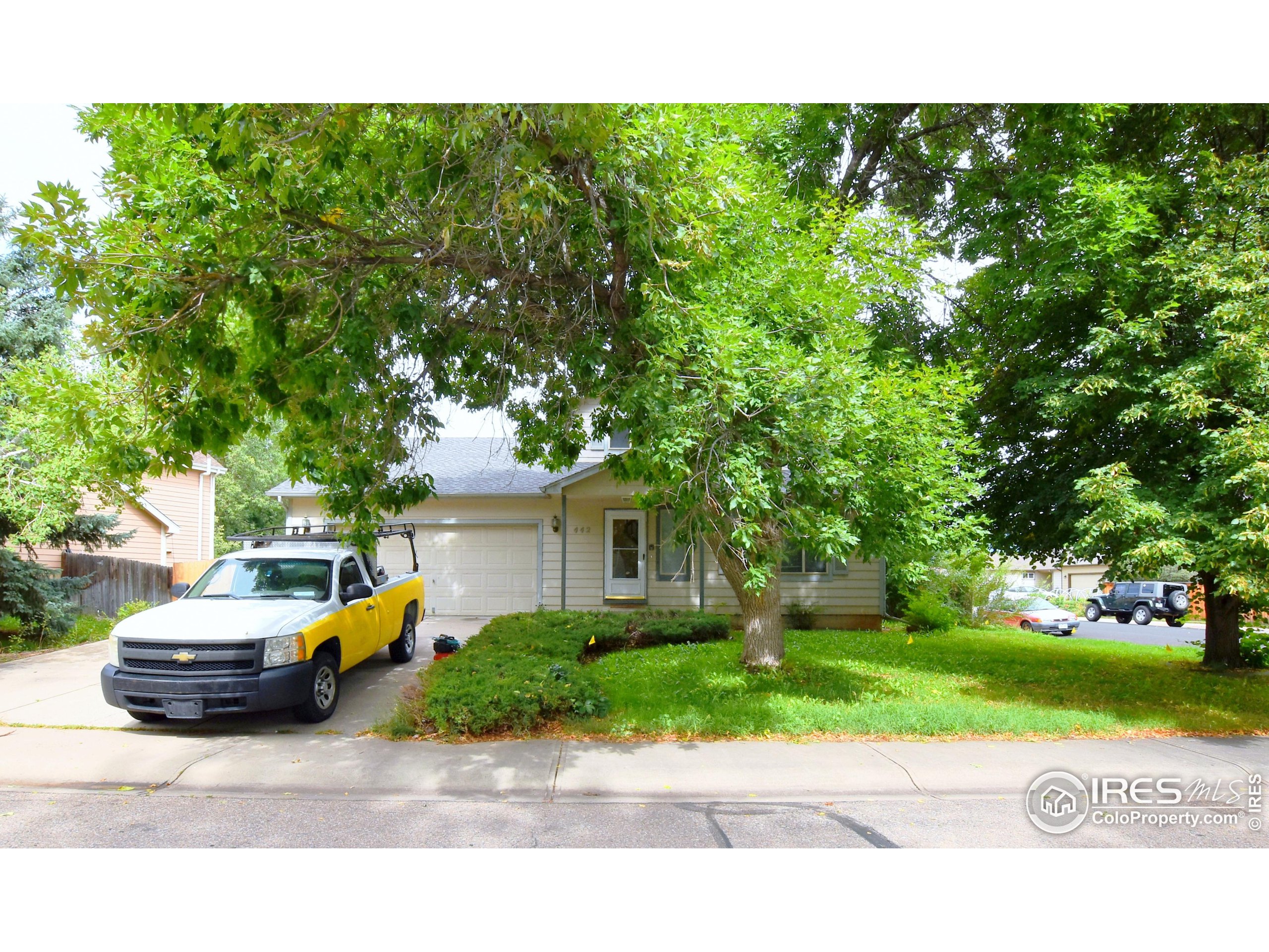 a car parked in front of a house with a yard