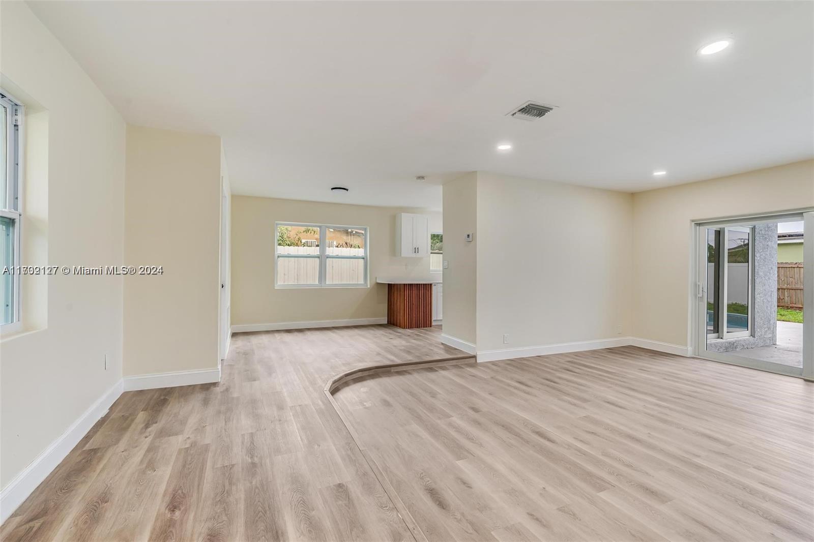 a view of a bedroom with wooden floor and window