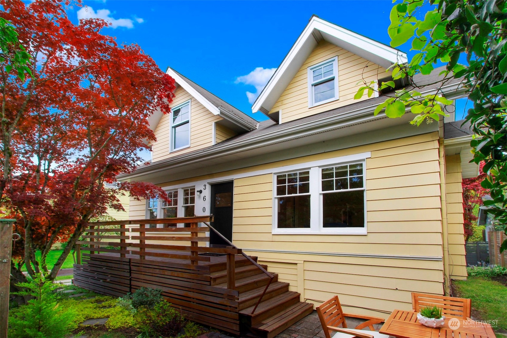 a view of a house with large windows and a small yard