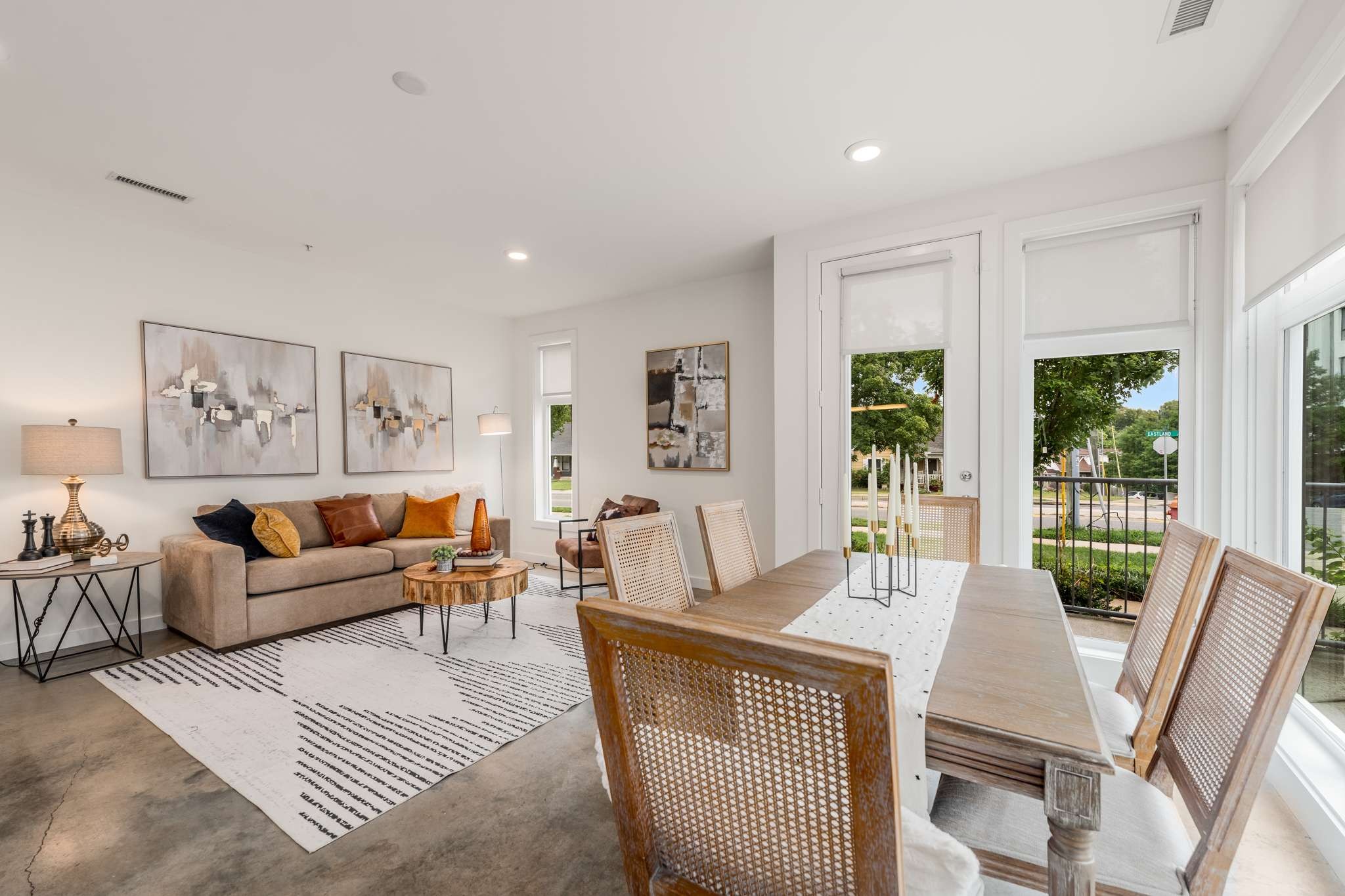 a living room with furniture a large window and a table