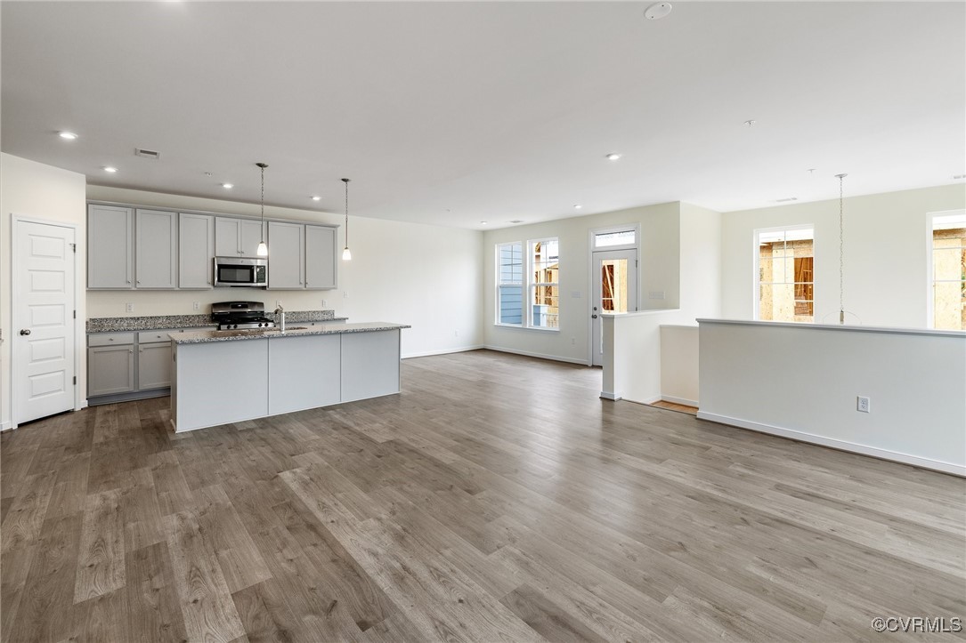 a large kitchen with cabinets wooden floor and a sink