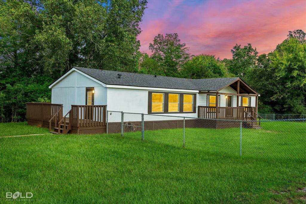 a front view of a house with yard and green space