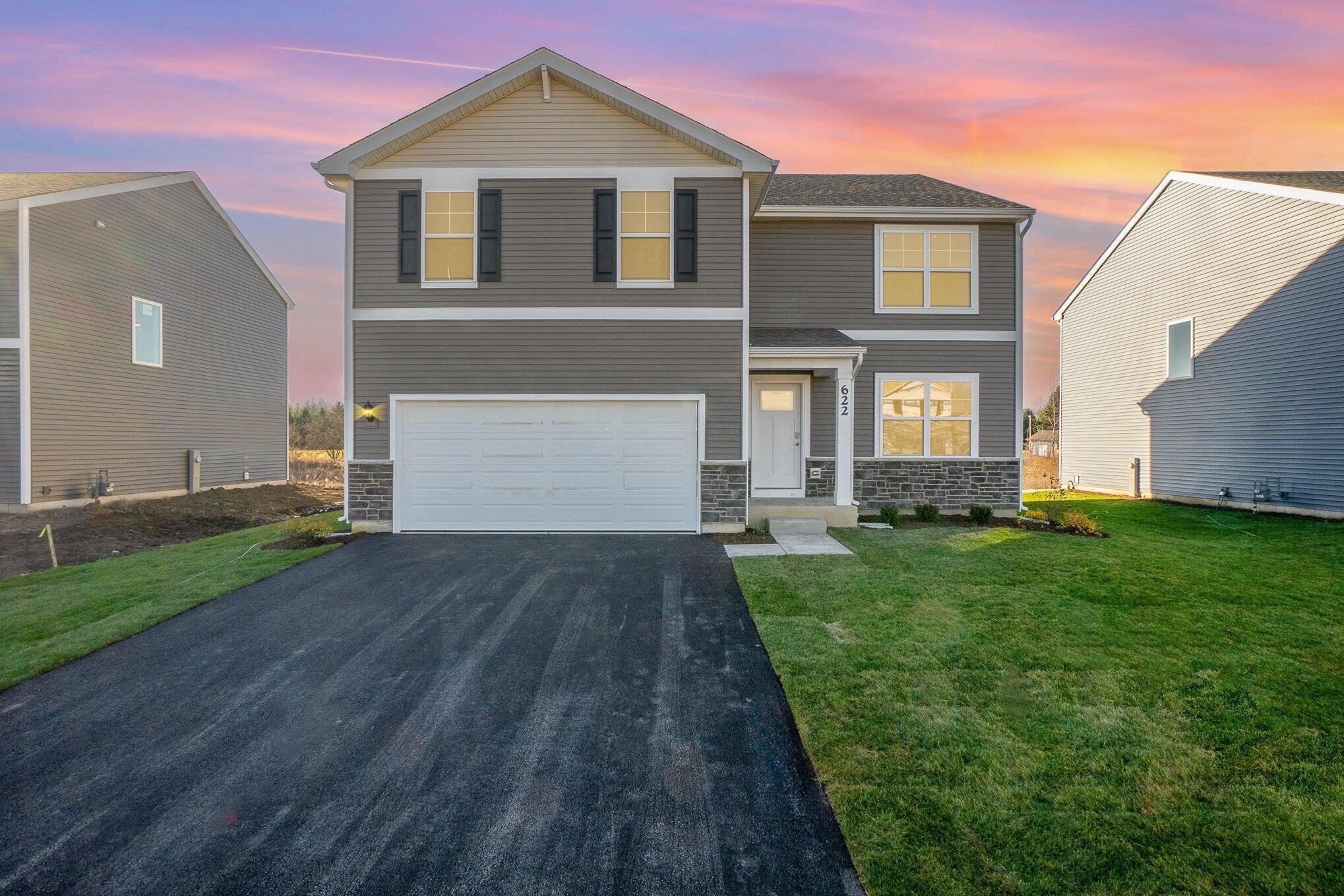 a front view of a house with a yard and garage