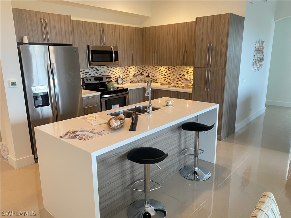 a kitchen with stainless steel appliances a table chairs and refrigerator