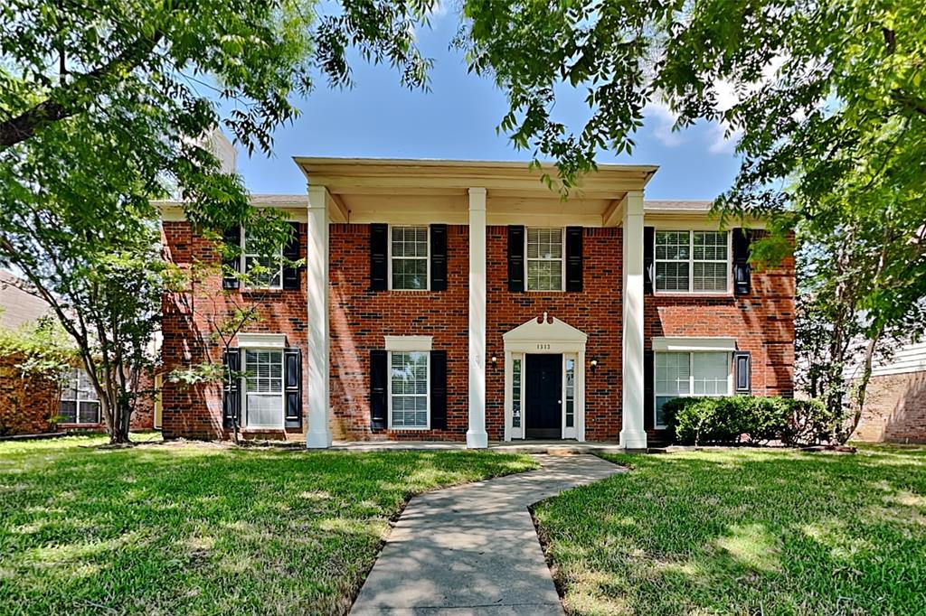 front view of a brick house with a yard