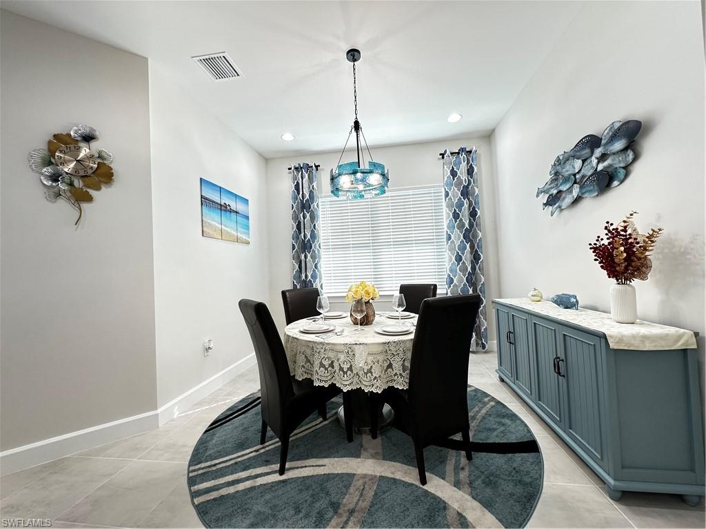 Dining area with a notable chandelier and light tile patterned floors