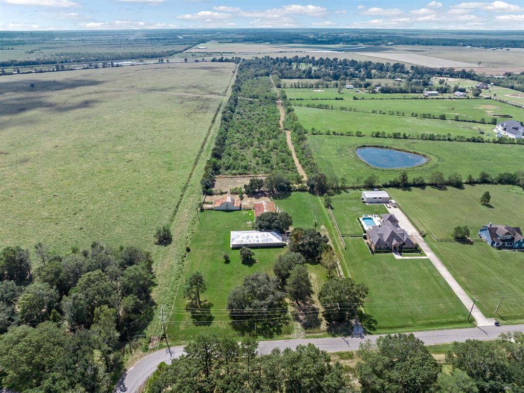 an aerial view of a residential houses with outdoor space and lake view