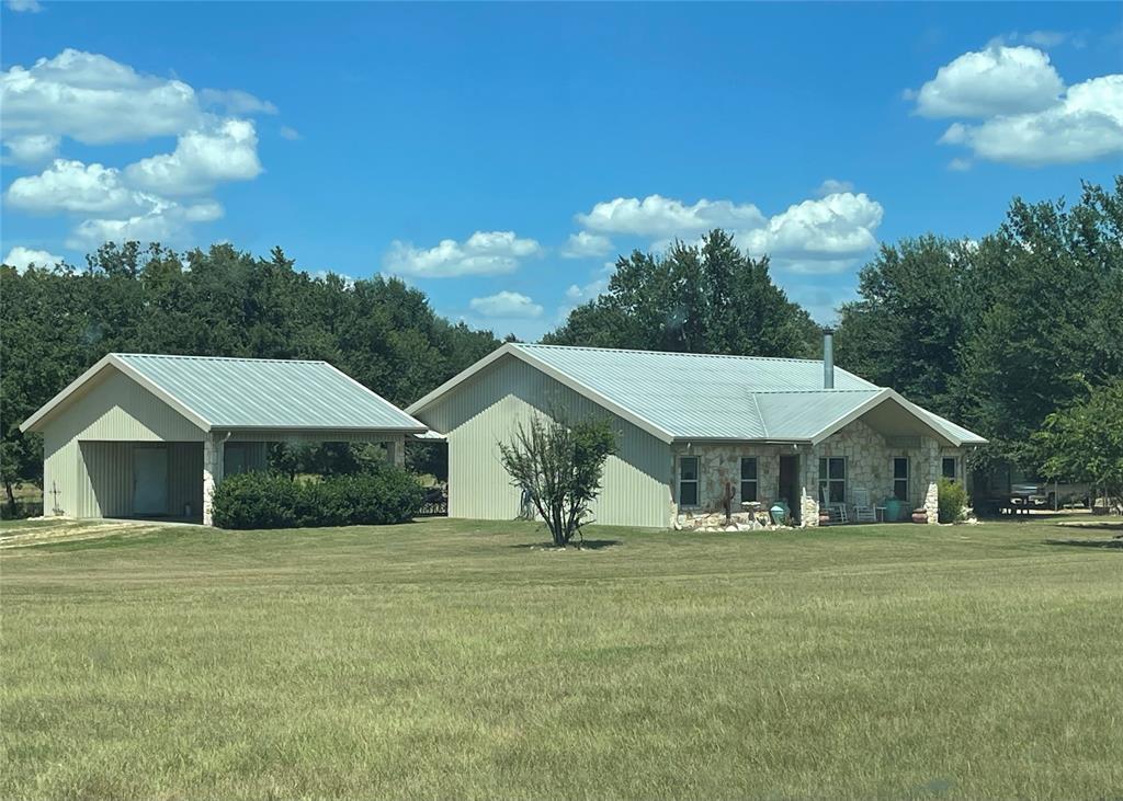 a house with green field in front of it