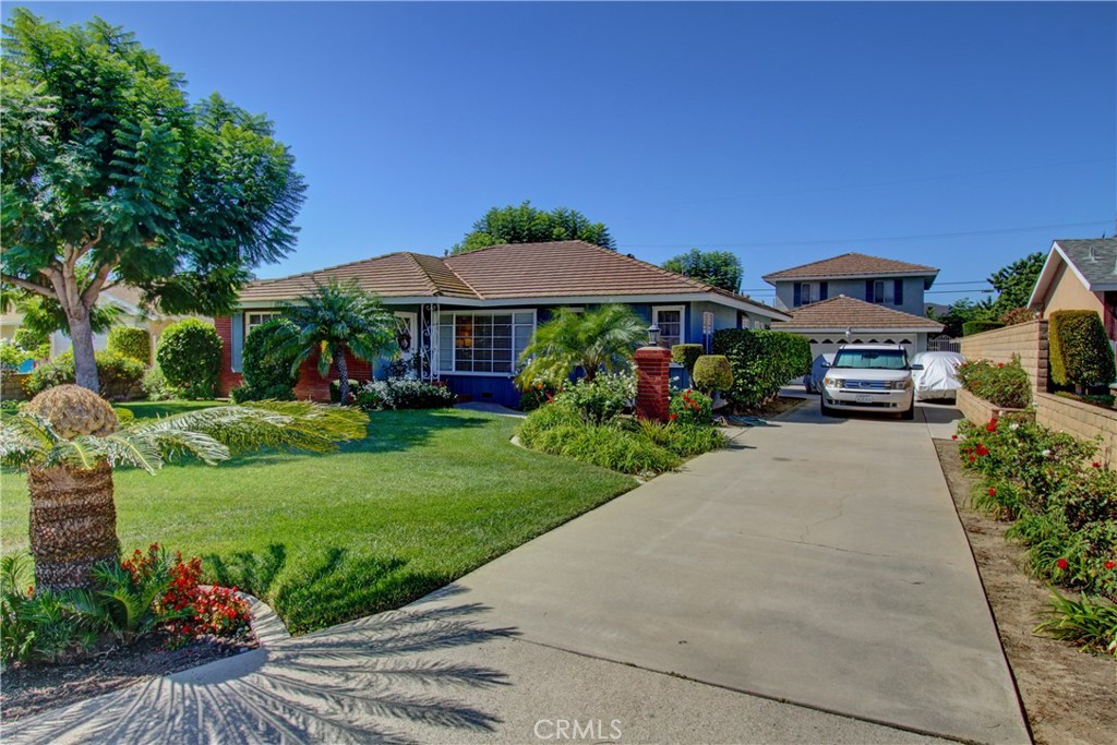 a front view of a house with a yard and a garden