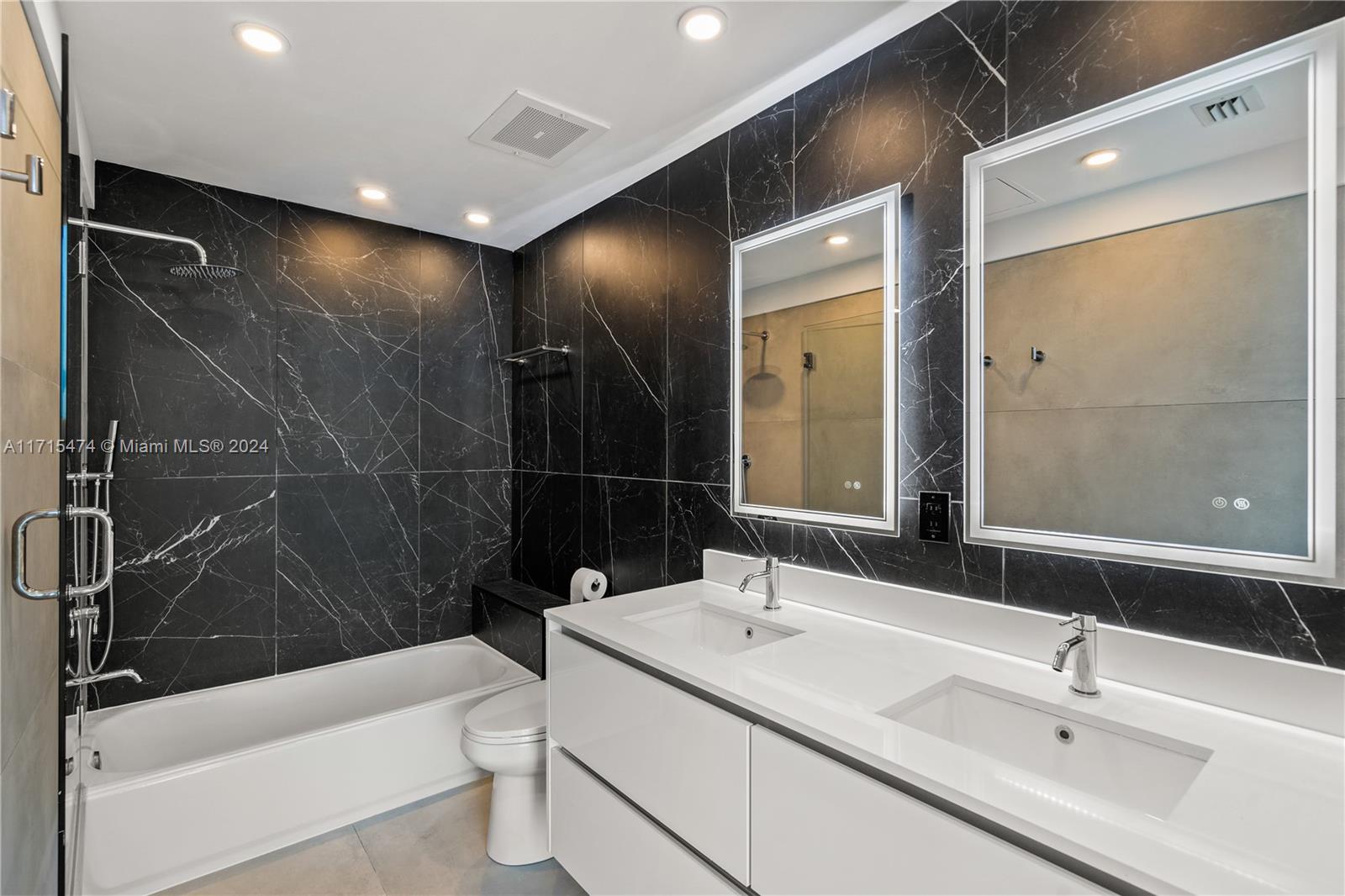 a bathroom with a bathtub shower sink mirror and toilet