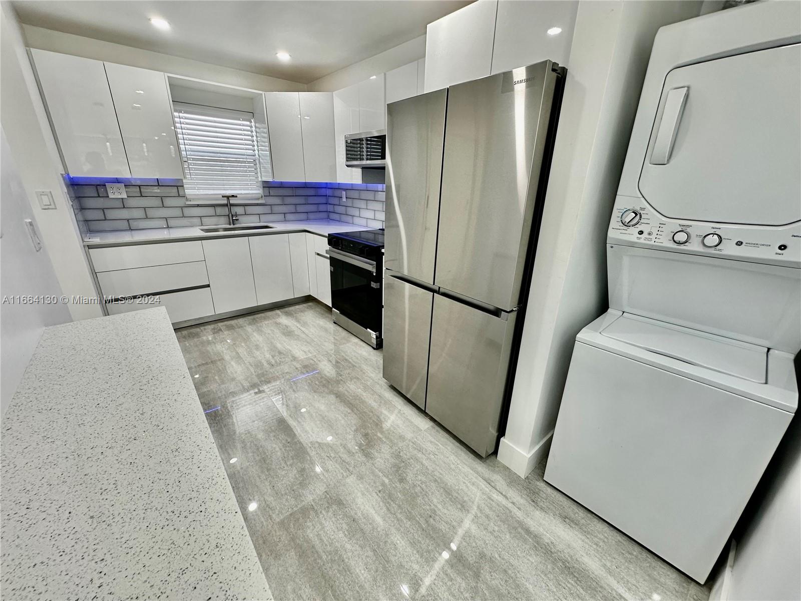 a kitchen with stainless steel appliances a refrigerator a sink a stove a microwave a counter top and cabinets