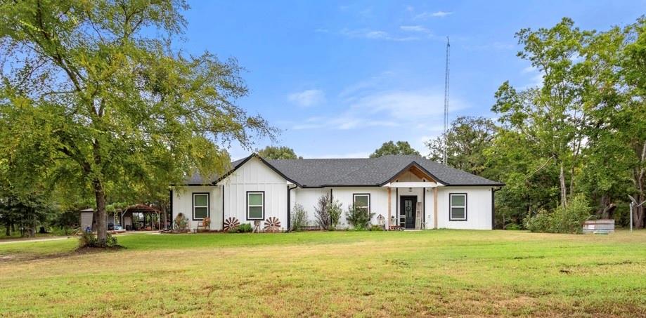 Modern inspired farmhouse featuring a front lawn