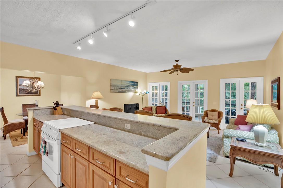 a view of a kitchen with granite countertop a sink and a refrigerator