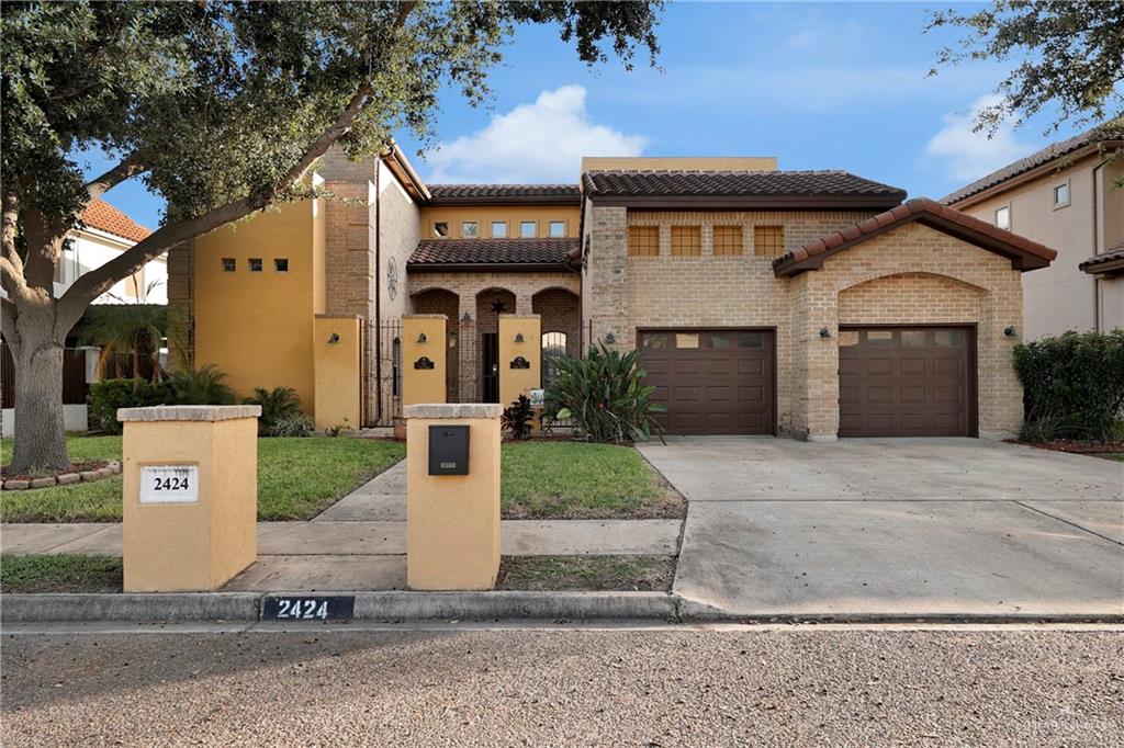 Mediterranean / spanish-style home featuring a front lawn and a garage