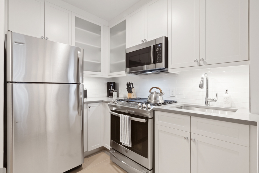 a kitchen with stainless steel appliances granite countertop white refrigerator stove a sink and dishwasher