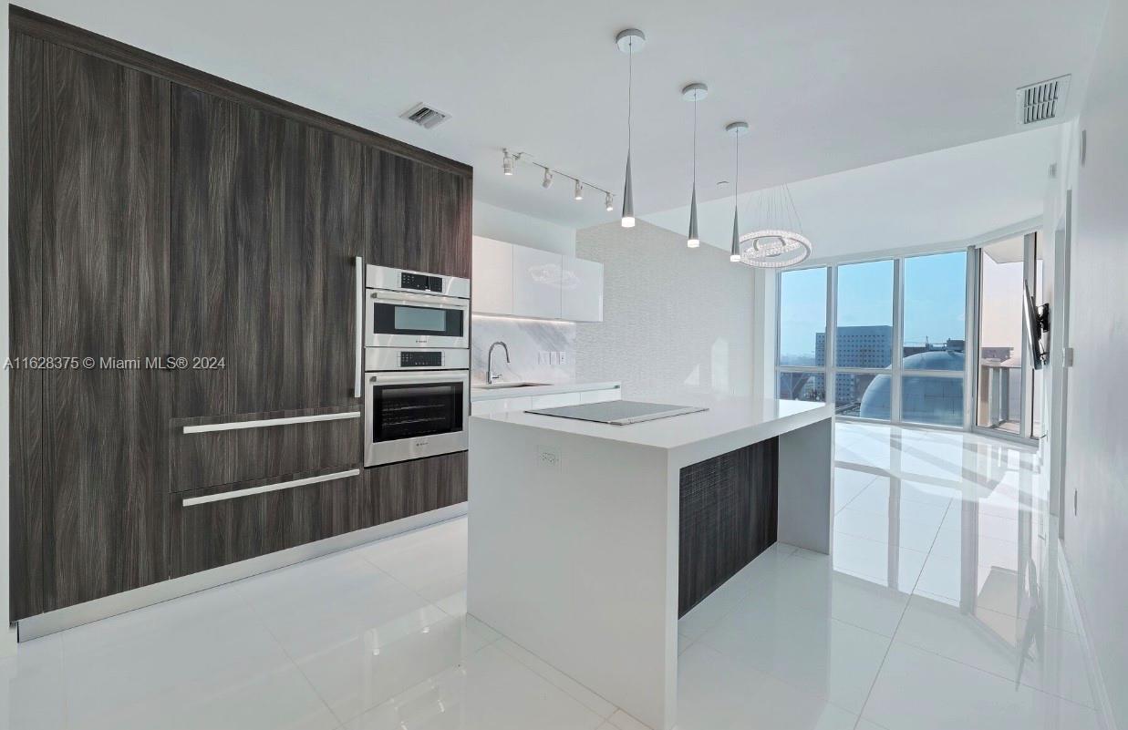 a kitchen with kitchen island a sink stainless steel appliances and cabinets