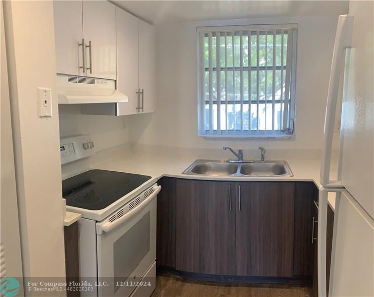 a kitchen with a sink cabinets and window