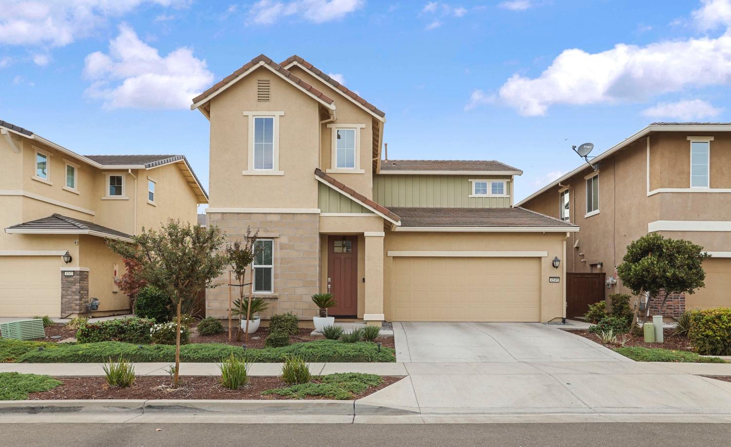 a front view of a house with a yard and garage